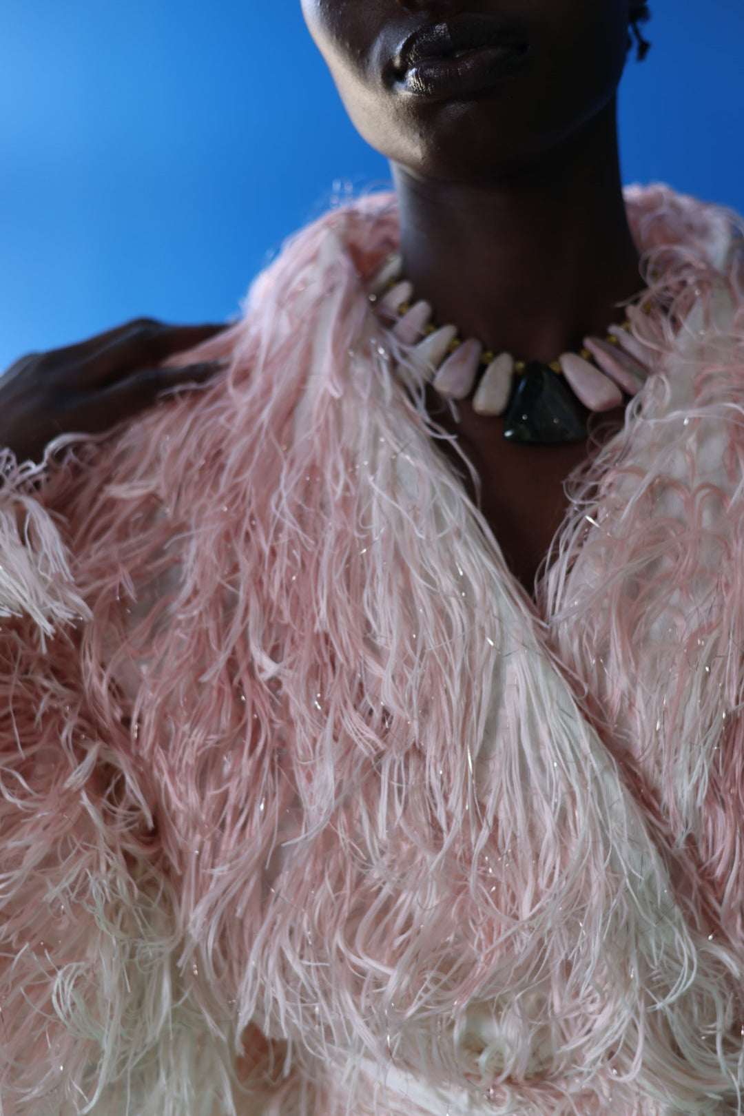 The Shaggy Brigitte Coat has an ombre effect from light pink to creamy white. Make it your own with your favorite jewelry.