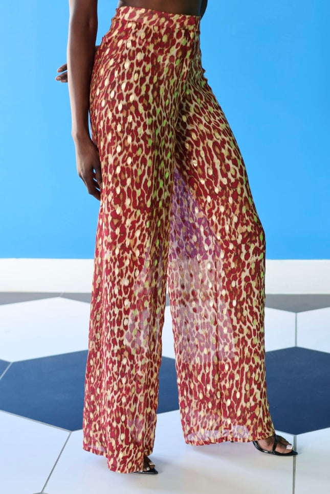 The Afet Pants feature a ruby red and beige cheetah print pattern.