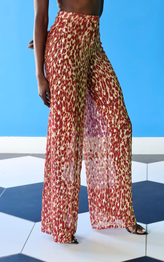 The Afet Pants feature a ruby red and beige cheetah print pattern.