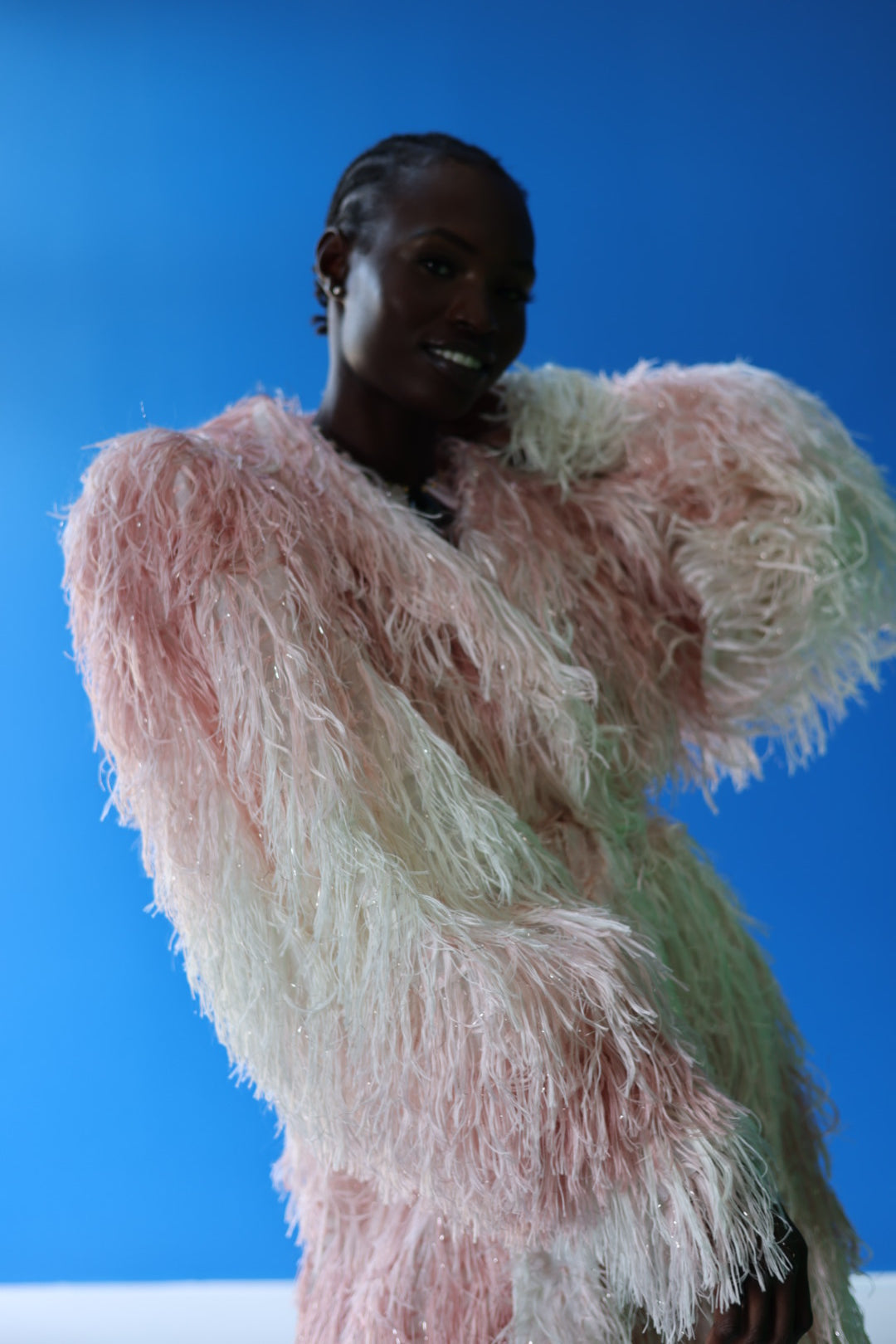 The Shaggy Brigitte Coat has an ombre effect from light pink to creamy white. The faux fur adds a playful touch.