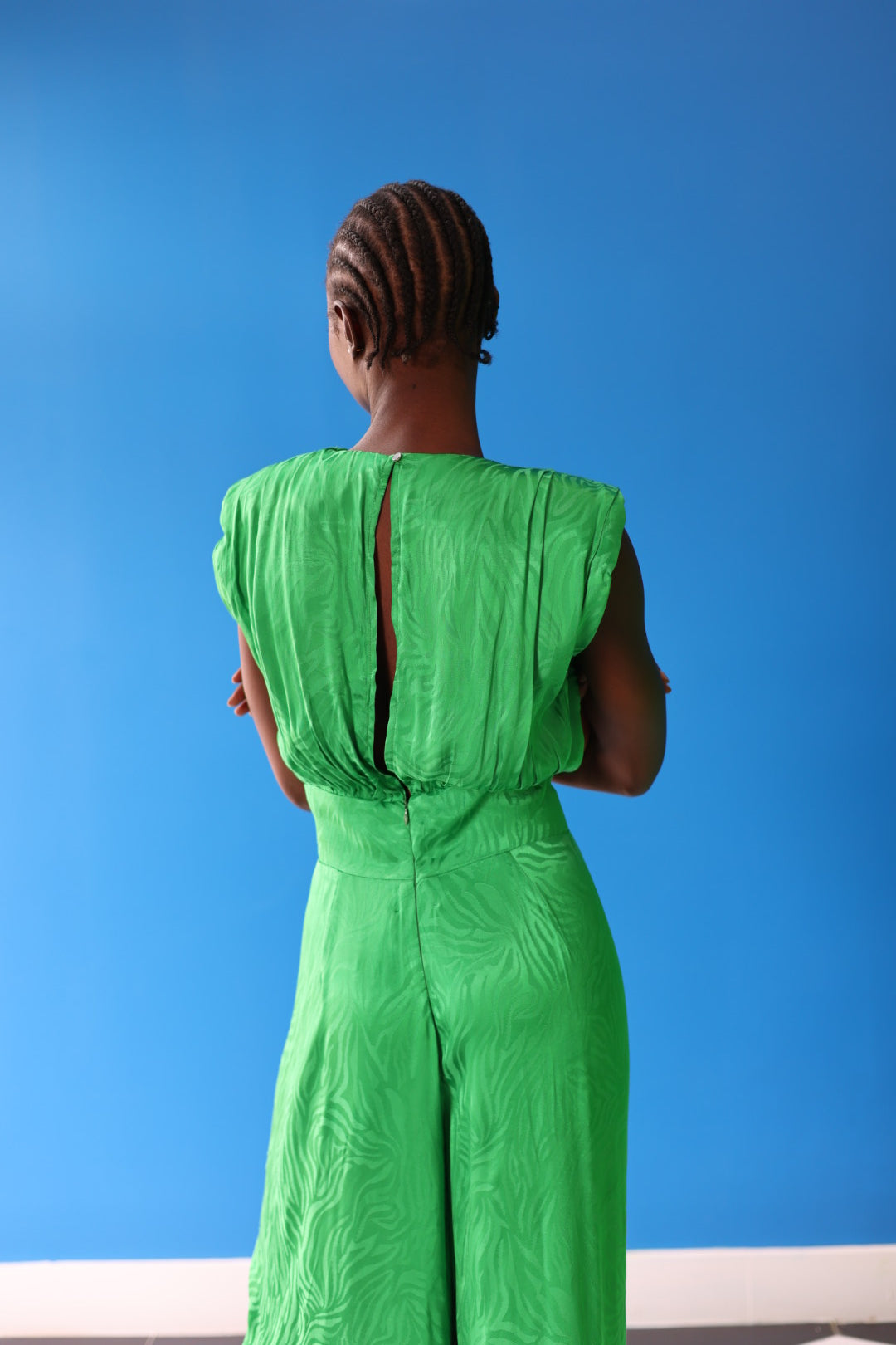 The celeste jumpsuit drapes elegantly down the body in a green-toned zebra print. The adjoining button allows for breathability and elegance.