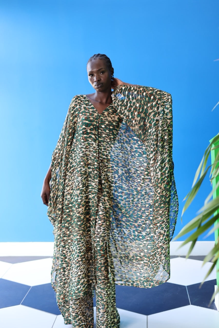 The Joanna Kaftan is a forest green and beige cheetah print kaftan with specks of gold and brown detailing throughout the design.