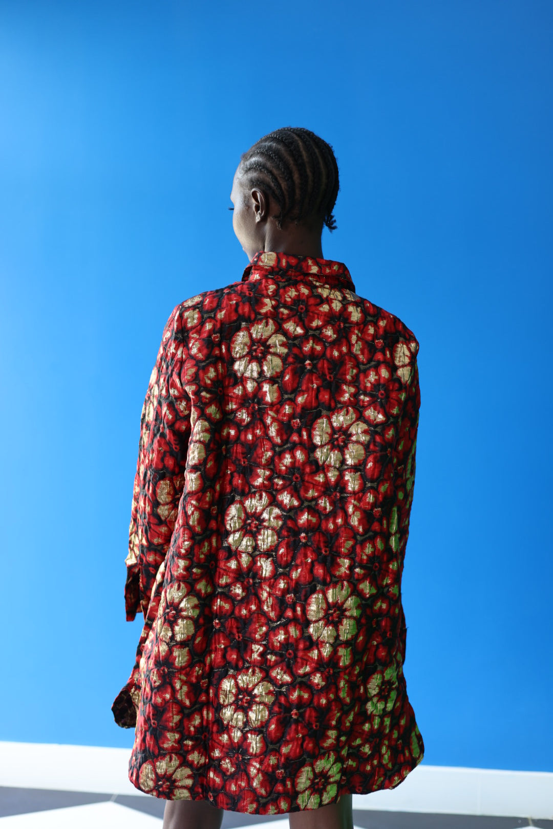 The Ophelia Button Top features red flowers with splashes of gold against a black background. She looks just as good from the back as she does from the front.