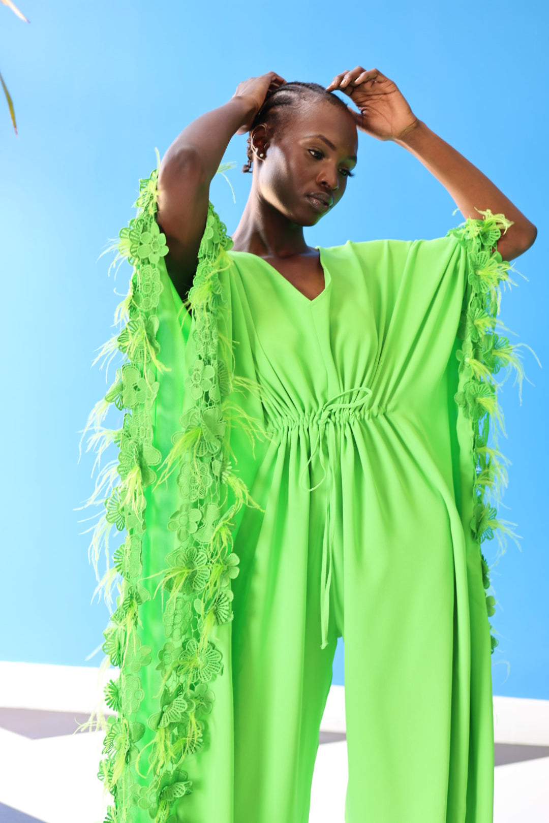 The Poppy Floral Jumpsuit in Green has gorgeous floral lace at the edge of the fabric, along with faux feathers that create a fun texture. Style this for a night out with strapped up heels or for a casual outing with comfortable tennis shoes.