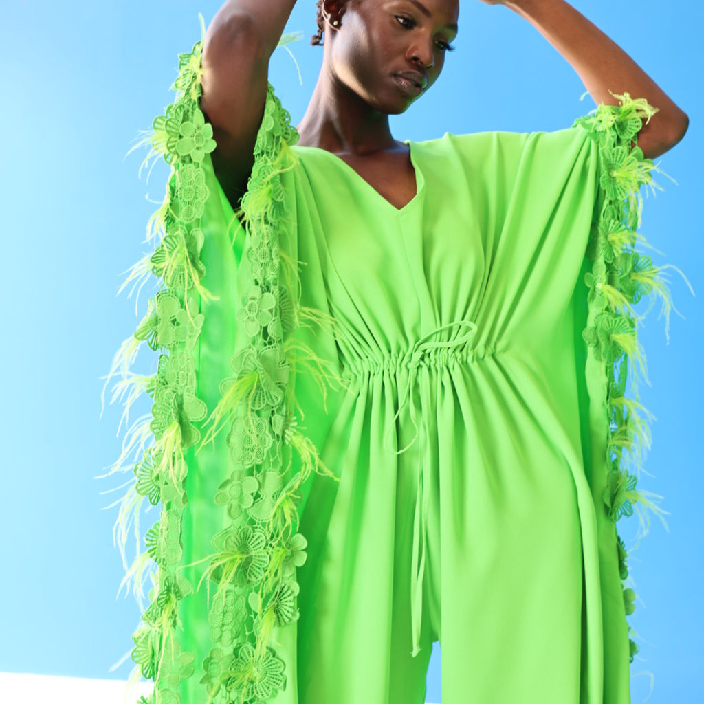 The Poppy Floral Jumpsuit in Green has gorgeous floral lace at the edge of the fabric, along with faux feathers that create a fun texture. Style this for a night out with strapped up heels or for a casual outing with comfortable tennis shoes.